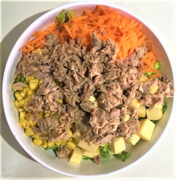 Ensalada con lomitos de atún, lechuga, zanahoria, dados de queso y choclo
