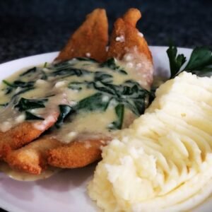 Filet de merluza con crema de rúcula y puré