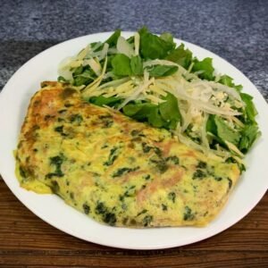 Omelet de pollo, verdura, jamón y champiñones con ensalada de rúcula, parmesano y cebolla