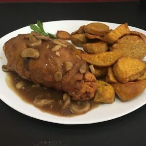 Suprema “Kiev” (Pechuga rebozada, rellena de manteca, perejil y acelga) con salsa champiñón y batatas