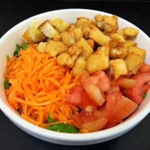 Ensalada de tomate, pollito crocante, zanahoria, crutones con oliva y colchón de rúcula