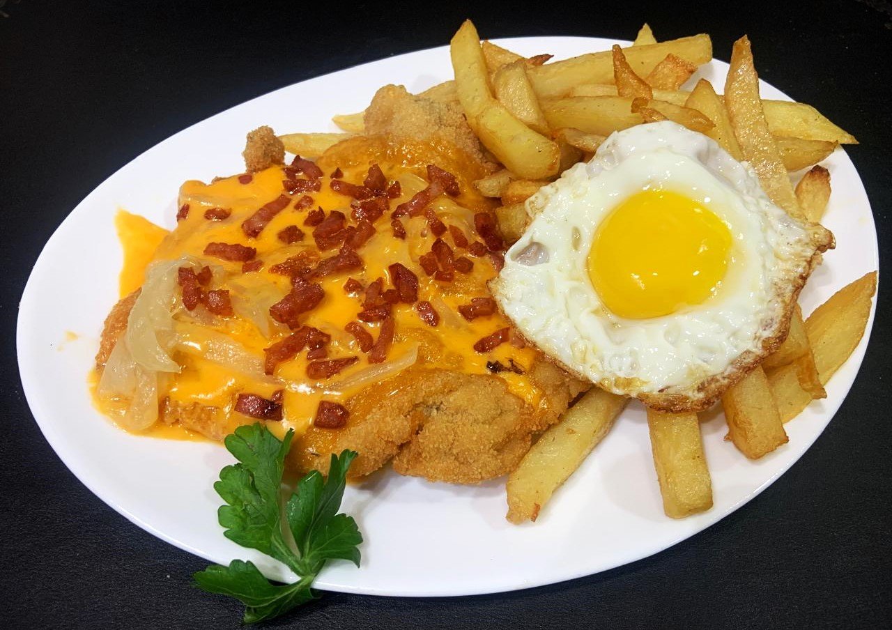 Milanesa “Magnífica” (Queso cheddar, cebolla dorada, panceta crujiente y fritas ½ caballo)