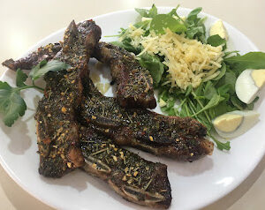 Asado de tira con ensalada de rúcula, parmesano y cebolla