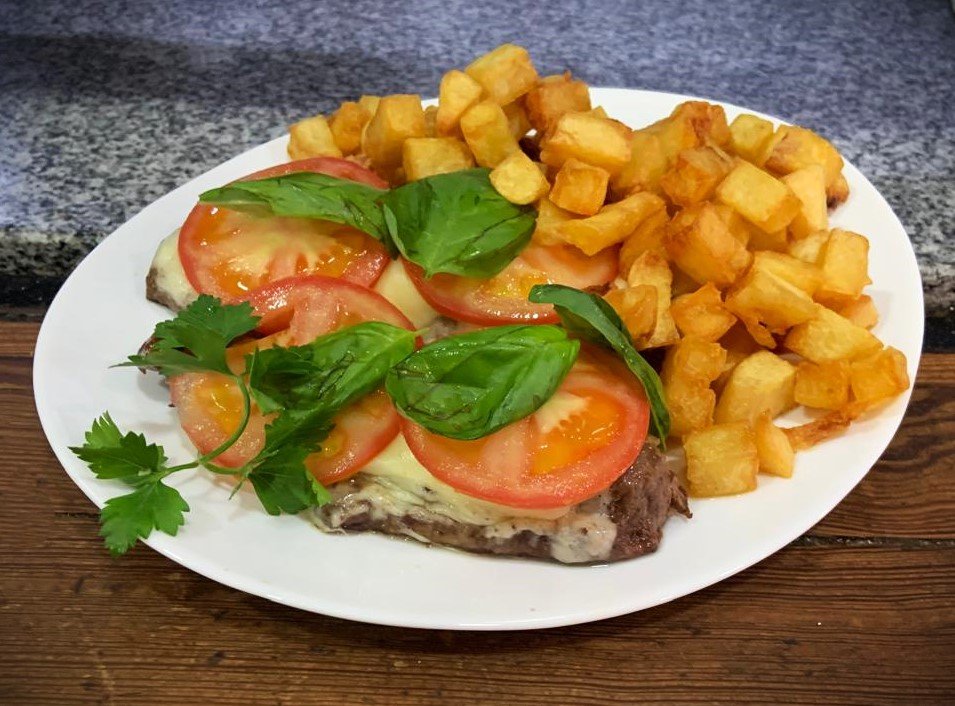 Bife de cuadril caprese con papas cuadrillé (Muzzarella, tomate y albahaca)