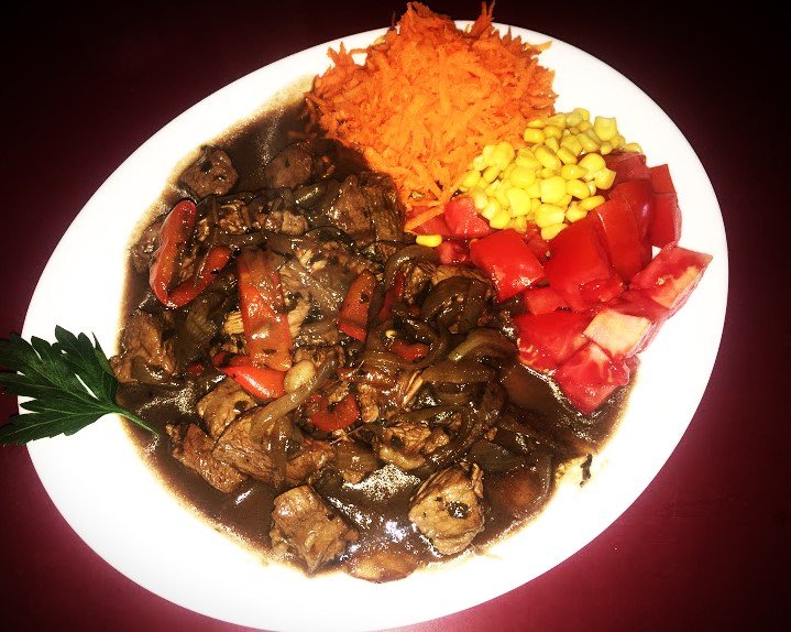 Churrasquito de cuadril salteado en cebolla y morrón con ensalada de zanahoria, tomate y choclo