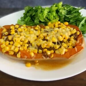 Calabaza rellena al gratén con ensalada de hojas verdes (Carne picada sazonada, cebolla, morrón, granos de choclo y parmesano gratinado)
